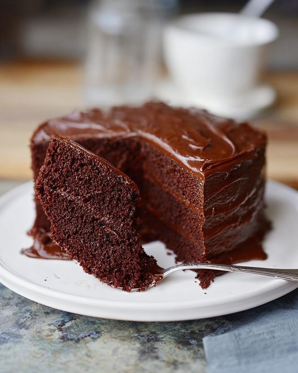 A slice of rich chocolate cake with glossy frosting, part of 7-Ingredient Cake Ideas Recipes.