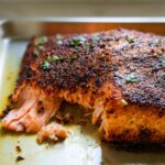 Close-up of a perfectly cooked salmon fillet with a seasoned crust, ready to be served.