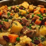 Close-up of a hearty beef stew with chunks of potatoes, carrots, peas, and dried cranberries in a creamy sauce, perfect for quick stuffing recipes.