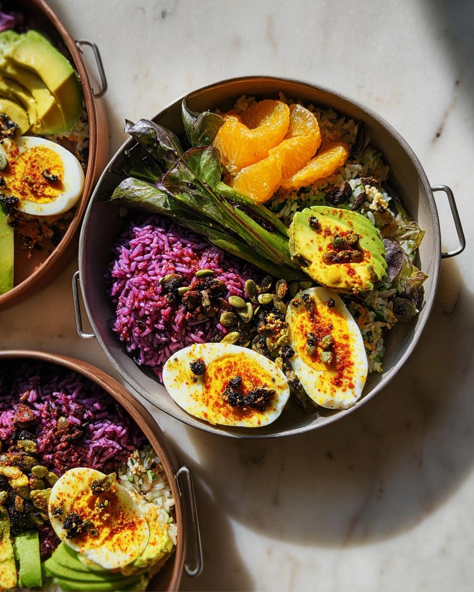 A vibrant rice bowl featuring purple rice, sliced avocado, orange segments, greens, and perfectly boiled eggs, part of The Ultimate Egg Recipes Guide for Beginners.