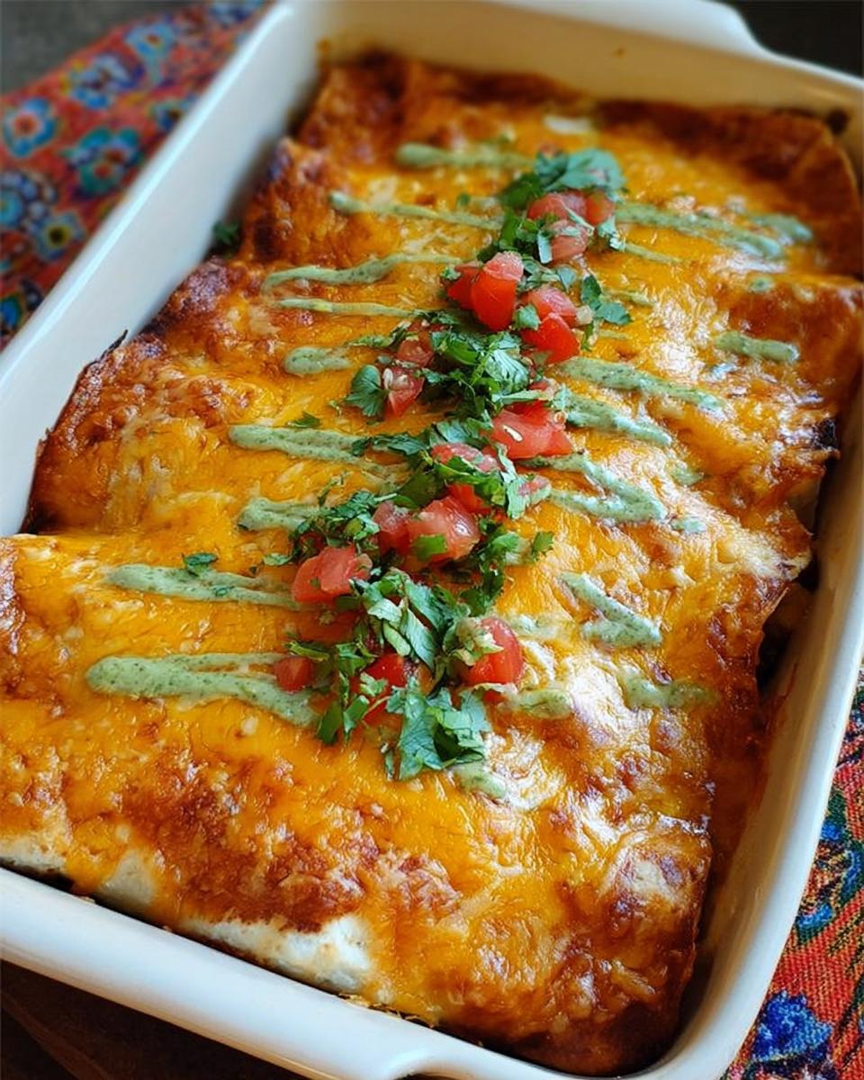 Golden baked chicken enchiladas topped with melted cheese, a drizzle of green sauce, chopped tomatoes, and cilantro.