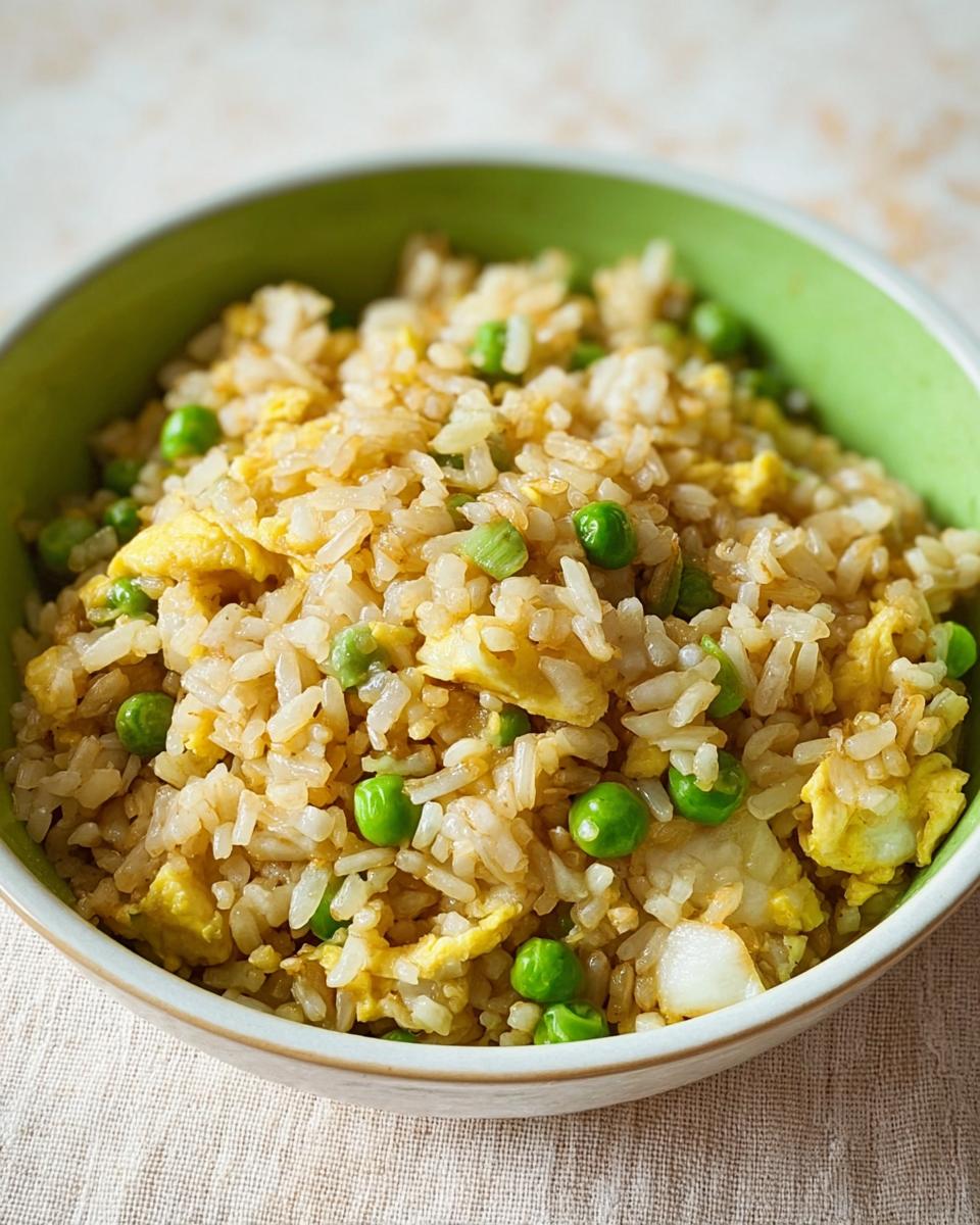 Close-up of a bowl of egg fried rice with peas and scrambled egg, showcasing one of the 7-Ingredient Egg Recipes.