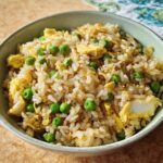 A bowl of easy egg fried rice with peas and scrambled egg, part of 7-Ingredient Egg Recipes.