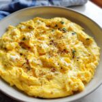 Close-up of fluffy scrambled eggs with herbs and spices in a white bowl, part of The Only Egg Recipes Recipe You’ll Need (2025).