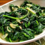 A close-up of garlicky sautéed spinach, a vibrant green vegetable side dish from the 20-Ingredient Veggie Sides Recipes.
