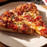 Two slices of homemade pizza with melted cheese and tomato toppings, perfect for pizza night recipes meal prep.