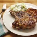 A perfectly cooked pork chop with a side of coleslaw, showcasing why everyone loves this pork chops recipe.