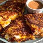 Golden-brown crispy quesadillas filled with melted cheese, served with a side of dipping sauce for Taco Tuesday.