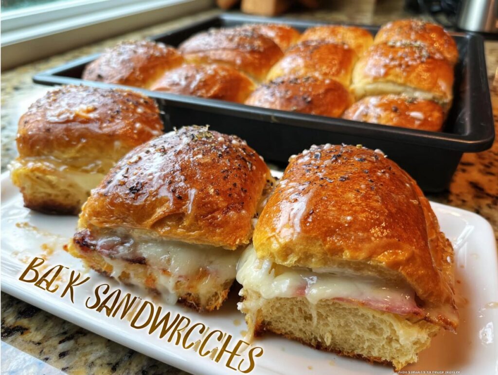 Two savory sandwich ideas recipes with melted cheese and ham on a white plate, with more sandwiches in a baking pan behind.