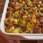 Close-up of a baking dish filled with homemade sausage cornbread stuffing, a delicious side dish.