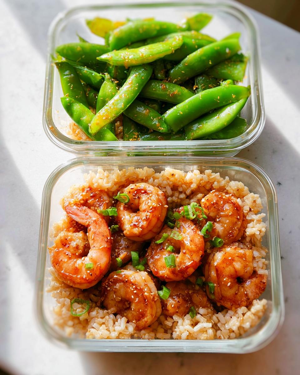 Two glass meal prep containers, one with glazed shrimp and rice, the other with seasoned snap peas. Perfect for shrimp recipes meal prep.