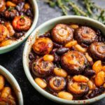 Close-up of a bowl filled with a delicious veggie sides recipe featuring whole mushrooms, kidney beans, and butter beans.