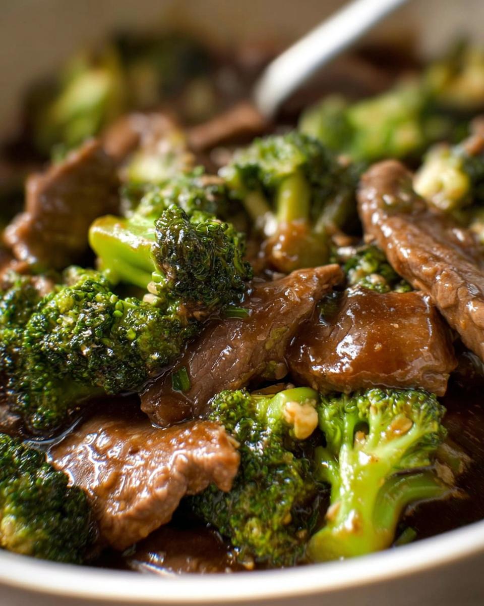 Close-up of tender beef slices and vibrant broccoli florets coated in a savory sauce, showcasing Chinese Beef and Broccoli.