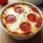 A close-up of a baked Cottage Cheese Pizza Bowl topped with melted cheese and pepperoni slices.