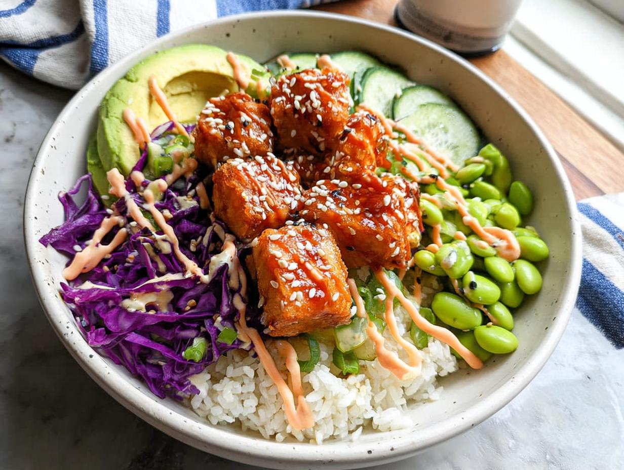 A delicious Crispy Salmon and Rice Bowl with avocado, edamame, cucumber, and red cabbage.