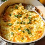 A close-up of golden-brown Baked Feta Eggs in a skillet, garnished with fresh parsley and black pepper.