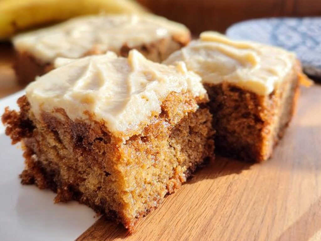 Close-up of two moist Banana Bread Brownies made easy, topped with creamy frosting.