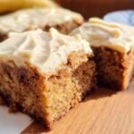 Close-up of two moist Banana Bread Brownies made easy, topped with creamy frosting.
