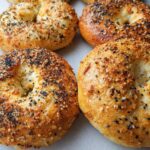 Close-up of golden-brown cottage cheese flagels topped with everything bagel seasoning.