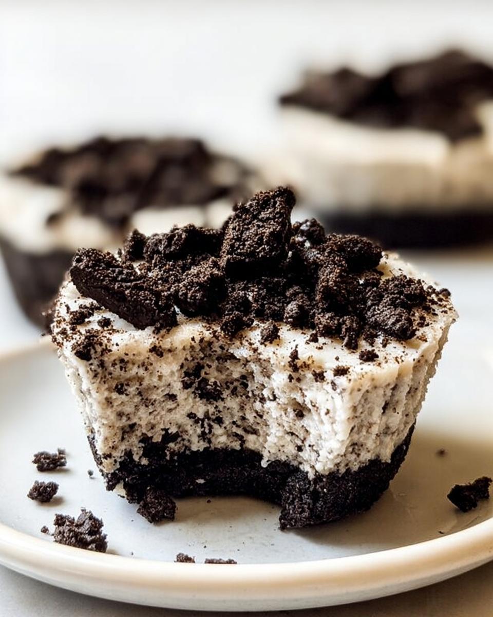 A bite taken out of a Healthy No-Bake Oreo Cheesecake Bite, showing the creamy filling and cookie crust.