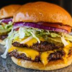 Close-up of an irresistible smash burger with double patties, melted cheese, lettuce, tomato, onion, and pickles.