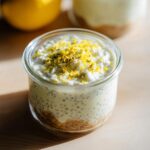 A close-up of a glass jar filled with creamy Lemon Cream Chia Pudding, topped with lemon zest.
