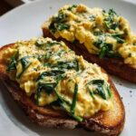 Two slices of toast topped with creamy scrambled eggs and spinach, seasoned with chili flakes. Spicy Buffalo Chicken Wraps for Two.