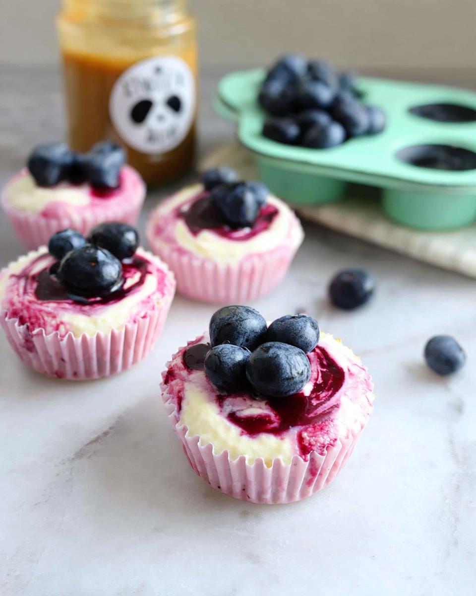 Close-up of easy blueberry swirl yogurt bites topped with fresh blueberries and swirl of blueberry sauce.