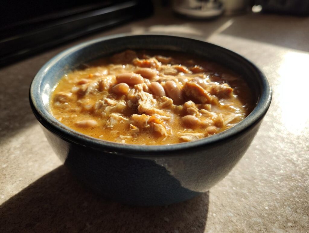 A bowl of creamy Slow Cooker White Chicken Chili full of flavor, with shredded chicken and white beans.
