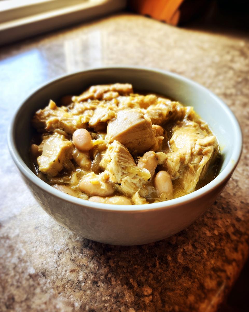 A bowl of flavorful Slow Cooker White Chicken Chili, showcasing tender chicken and white beans in a creamy broth.